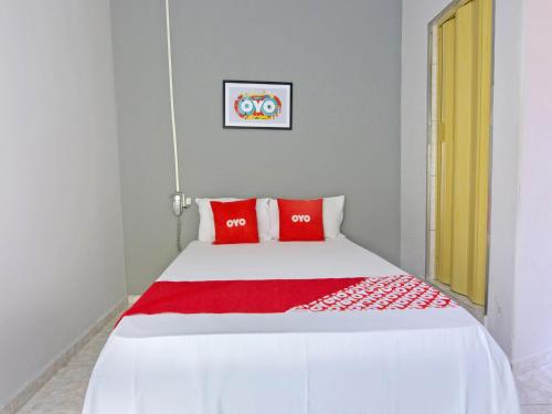 サンパウロにあるOYO Hotel Castro Alves, São Pauloの白いベッド(赤い枕付)
