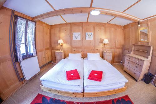 a bedroom with a large bed and two red pillows at Guest House du Grand Paradis - On Piste in Champéry