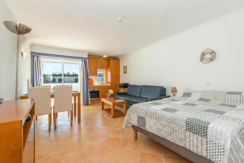 a bedroom with a bed and a dining room at Quinta Velha By Algartur in Cabanas de Tavira