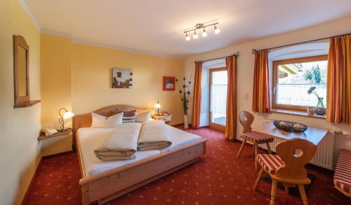 a bedroom with a bed and a table and chairs at Gästehaus Wöbelerhof in Ehrwald