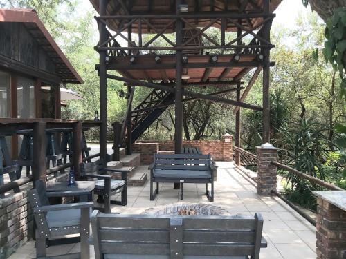 a pavilion with benches and a fire pit at Peace@Kruger in Marloth Park