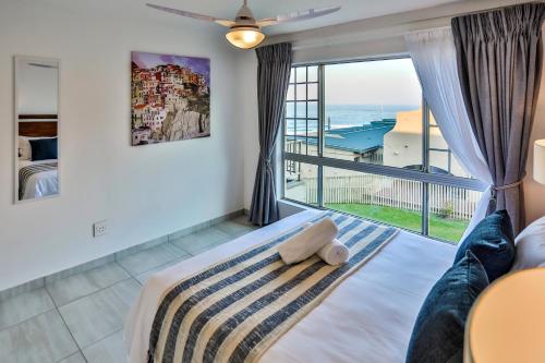a bedroom with a bed and a large window at 302 Kenwyn on Sea- Luxury Beachfront Getaway in Ballito