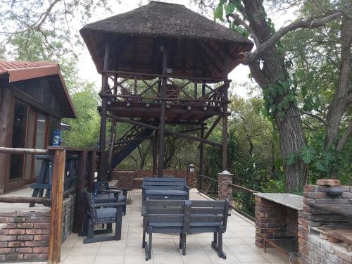 a wooden gazebo with chairs and a tree at Peace@Kruger in Marloth Park