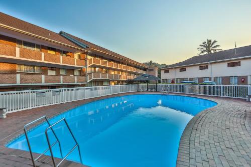 a large blue swimming pool in front of a building at 302 Kenwyn on Sea- Luxury Beachfront Getaway in Ballito
