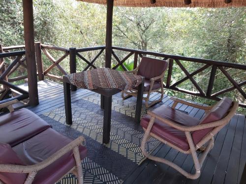 a porch with two chairs and a table and a table at Peace@Kruger in Marloth Park