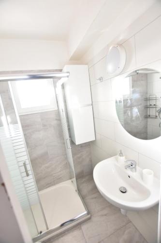 a white bathroom with a shower and a sink at Glabur Stays - The Cozy 2 BDR - Nicosia City, Free Parking & Wifi, Welcomes You!!! in Nicosia