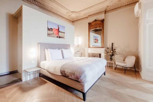 una camera con un grande letto bianco e una sedia di Maison Haas Hustinx & Spa a Maastricht