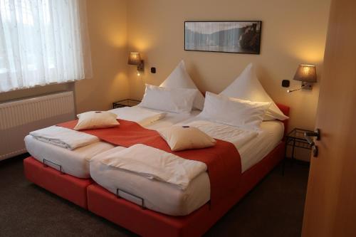 a hotel room with a large bed with white pillows at Gästehaus Köglmaier in Kelheim