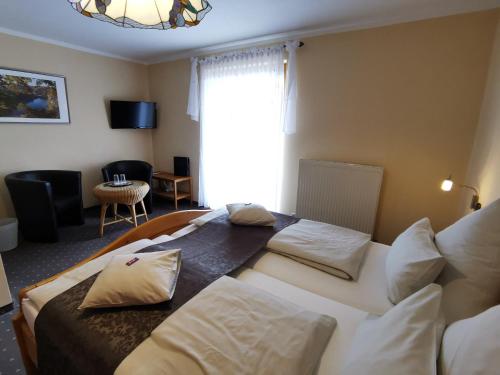 a hotel room with two beds and a window at Gästehaus Köglmaier in Kelheim