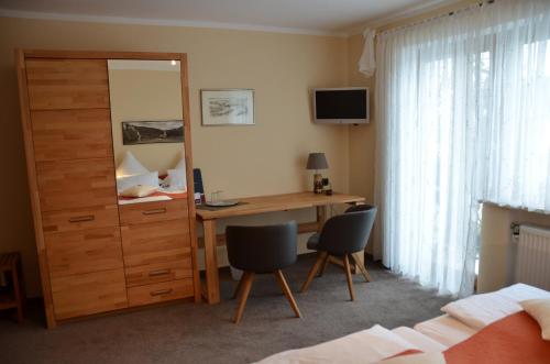 a bedroom with a desk with two chairs and a mirror at Gästehaus Köglmaier in Kelheim