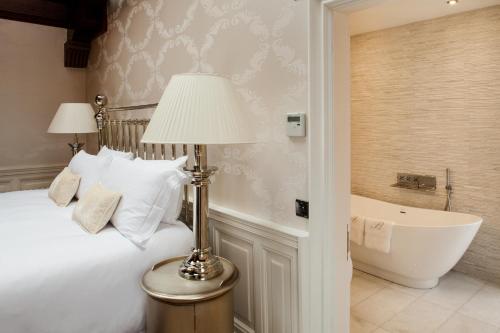 a hotel room with a white bed and white walls at Fonab Castle Hotel in Pitlochry