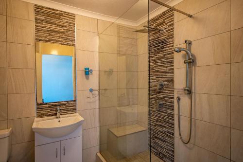 ein Bad mit einer Dusche, einem WC und einem Waschbecken in der Unterkunft Cozumel 320 in Umdloti