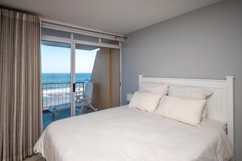 a bedroom with a bed with a view of the ocean at Cozumel 320 in Umdloti
