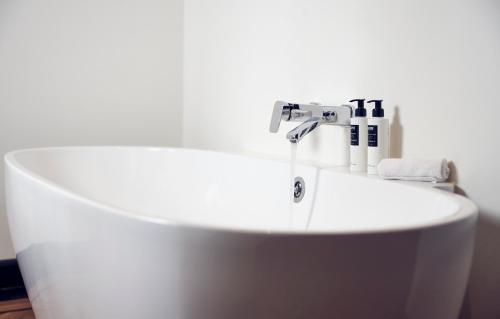 a white bath tub sitting next to a white sink at Hotel New York in Rotterdam