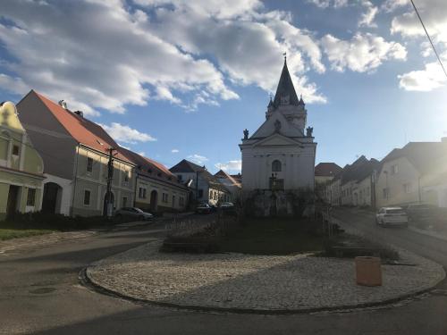 a building with a clock tower in the middle of a street at Apartmán U Venuše in Pavlov