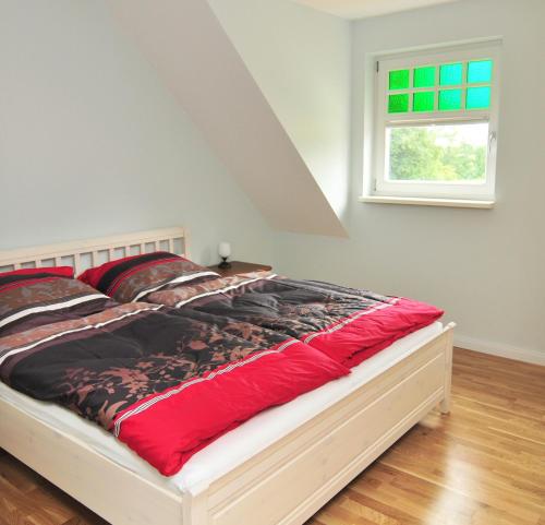 a bed in a white room with a window at Schloms Hof in Waffensen