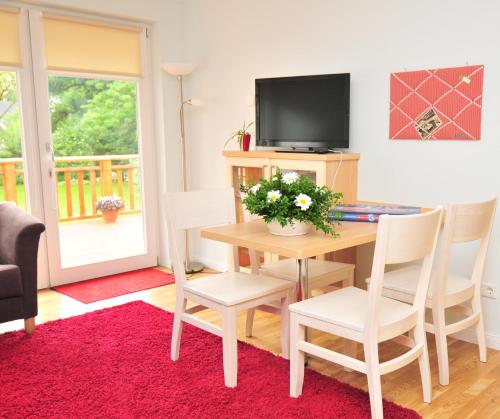 a living room with a table and a tv at Schloms Hof in Waffensen