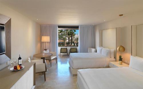Paradisus Los Cabos - Adults Only - All Inclusive في كابو سان لوكاس: غرفة فندقية بسريرين وطاولة