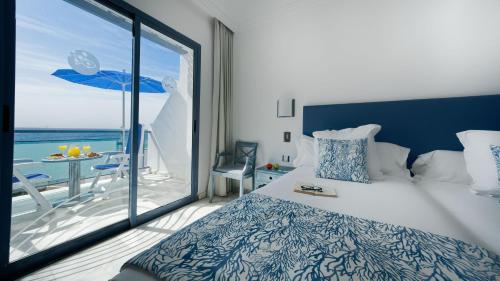 um quarto com uma cama e vista para o oceano em Apartamentos Igramar MorroJable - Adults Only em Morro del Jable