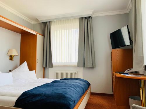 a hotel room with a bed and a flat screen tv at Seehotel Neue Liebe in Cuxhaven