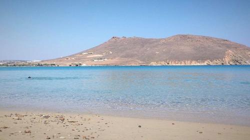 a beach with a hill in the background with a mountain at Molos Sea View House - Paros Greece in Molos Parou