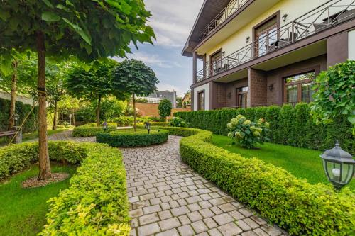 a garden with a brick walkway in front of a building at Petrani Nivki in Kyiv