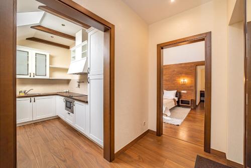 uma cozinha com armários brancos e uma porta que leva a um quarto em Petrani Nivki em Kiev