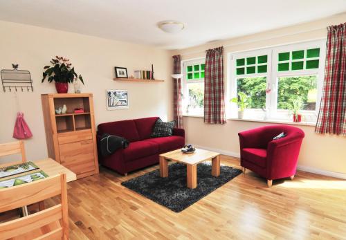 a living room with a red couch and a table at Schloms Hof in Waffensen