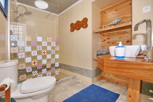 a bathroom with a toilet and a sink at A Casinha Azul in Vila Franca do Campo