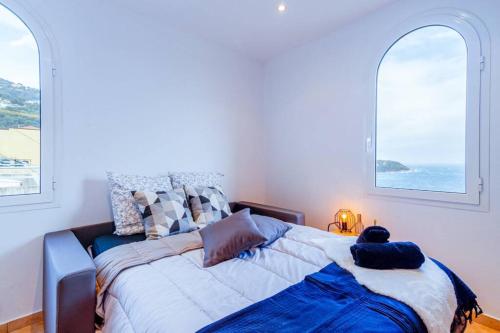 a bedroom with a large bed with two windows at Brand New Studio, Sea View, AirCon, Wifi in Roquebrune-Cap-Martin