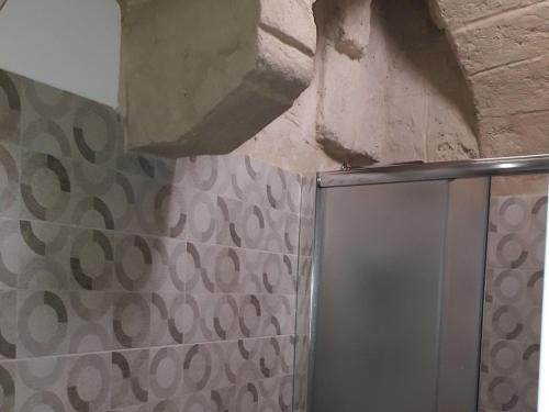 un bagno con doccia con parete in pietra di Sant'Onofrio apartment a Bari