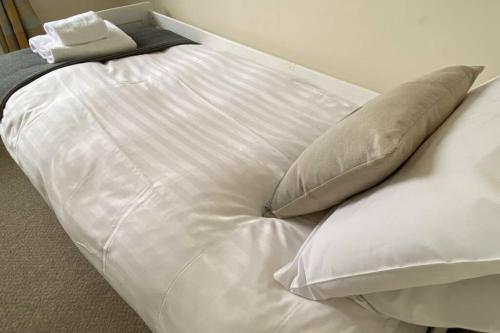 Una cama blanca con dos almohadas encima. en River Walks Retreat en Bothal
