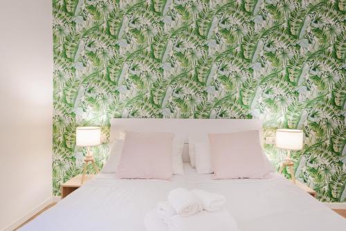 ミラノにあるNew & cozy apt in Porta Romanaの緑と白の壁紙を用いたベッドルーム1室