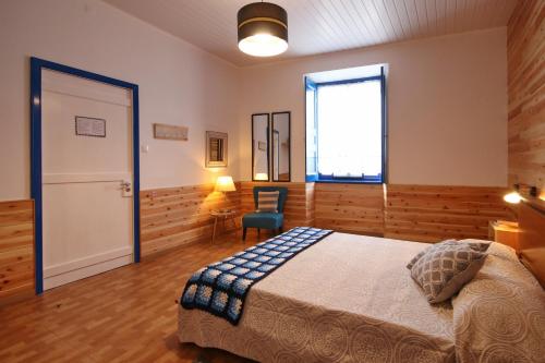 a bedroom with a bed and a window and a door at A Casinha Azul in Vila Franca do Campo