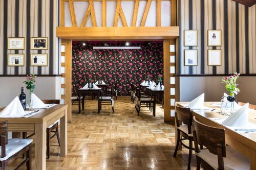 a dining room with tables and chairs and a floral wall at Europejski Boutique Hotel in Radom