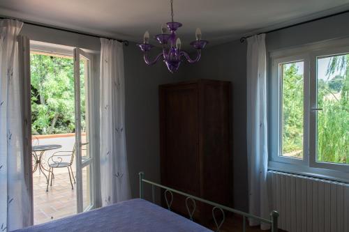 a bedroom with a bed and a chandelier at Agriturismo La Solagna in Montebello di Bertona