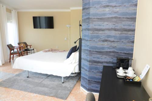 a bedroom with a bed and a wall with a tv at Rallye Hotel in L'Escala
