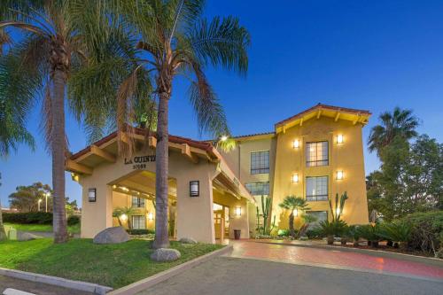 un edificio con palmeras delante en La Quinta Inn by Wyndham San Diego - Miramar, en Sabre Springs