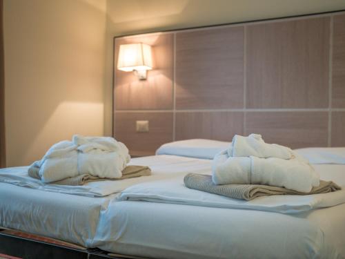 a hotel room with two beds with towels on them at Hotel Capo Reamol in Limone sul Garda