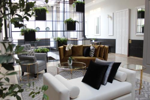 a living room with couches and tables and plants at Hotel Boutique Margarita Toluca in Toluca