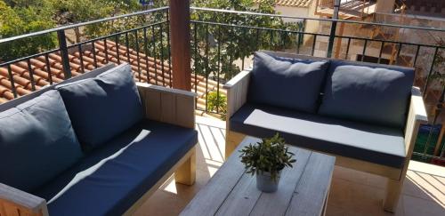 a balcony with a blue couch and a wooden table at Anemos in Afionas