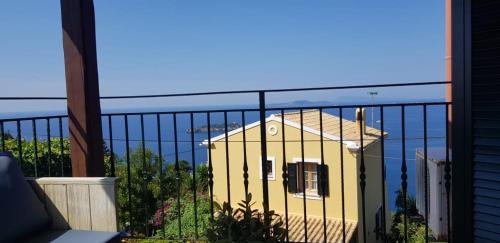 a yellow house sitting on top of a balcony at Anemos in Afionas