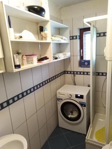 a small bathroom with a washing machine in it at Apartman Mimi in Klenovica