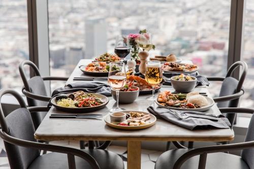 a table with plates of food and glasses of wine at InterContinental - Los Angeles Downtown by IHG in Los Angeles
