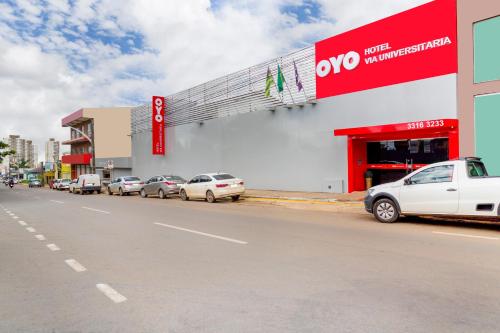 a store with cars parked in front of a street at OYO Hotel Via Universitária, Anápolis in Anápolis
