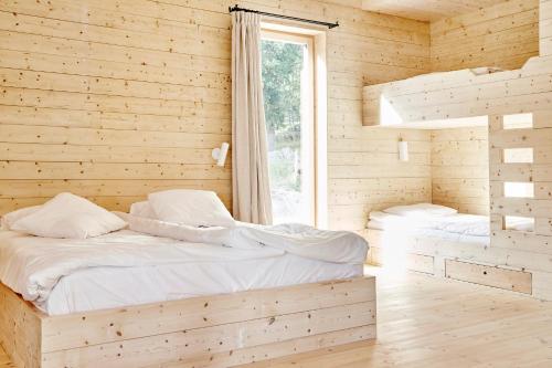 Lindeborgs Eco Retreat في Vrena: سريرين في غرفة خشبية مع نافذة