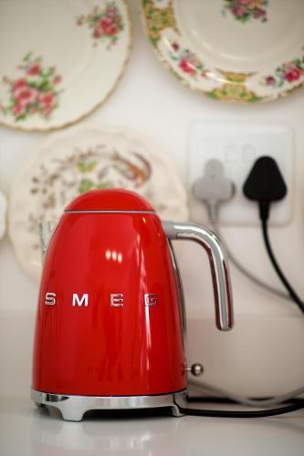 a red tea kettle sitting on a table at Batavia Boutique Hotel in Stellenbosch