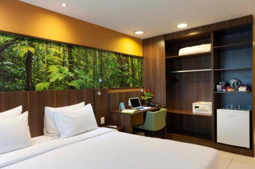 a bedroom with a bed and a desk with a computer at Mercure Rio de Janeiro Nova Iguaçu in Nova Iguaçu