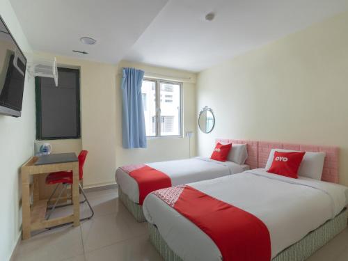 クアラルンプールにあるOYO 89717 Budget Star Hotelのベッド2台とテレビが備わるホテルルームです。