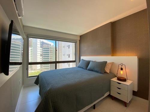 een slaapkamer met een bed en een groot raam bij Apartamento de Luxo em Boa Viagem Perto da Praia. in Recife